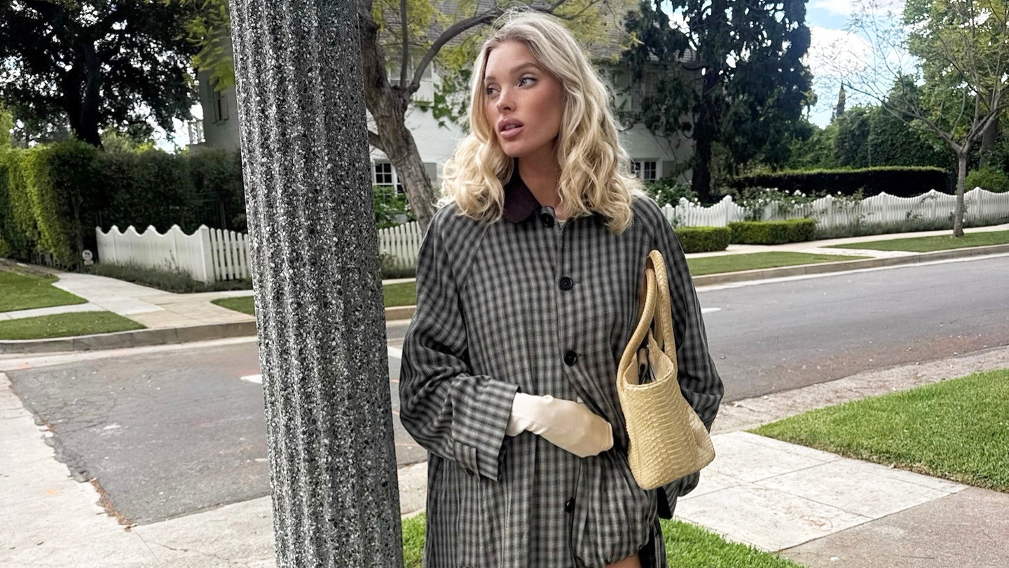 Elsa Hosk wearing a Helsa trench and shorts with a Chanel tote and Comme Si Yves Socks in Khaki