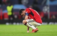 A crouching Bruno Fernandes stares down at the ground following defeat to Bayern Munich