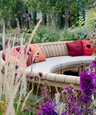 curved wooden garden bench seating surrounded by planting