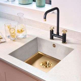 Striking bridge tap on a square kitchen sink