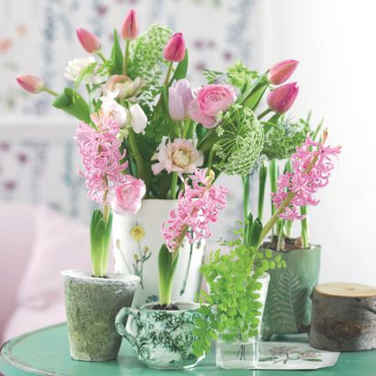 Cut flowers in white vase including pink tulips, roses and pink hyacinth