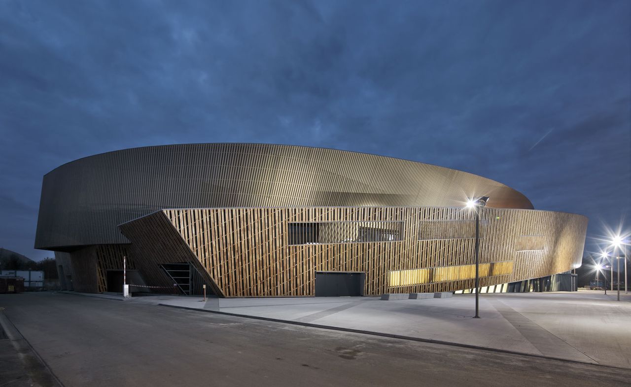 New convention centre in Mons, lit up at night by internal lighting together with street lights surrounding the building