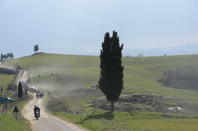 The peloton in hot pursuit of the early break over a sector of gravel roads