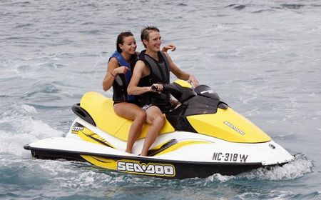 Andy Schleck rides a jet ski with a friend.