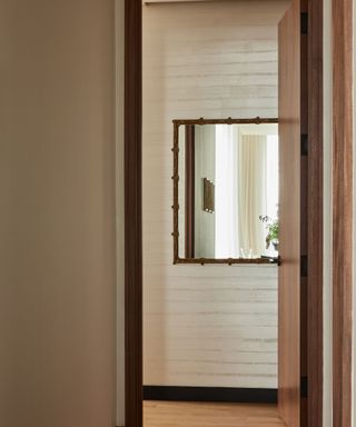 A square mirror in a neutral hallway