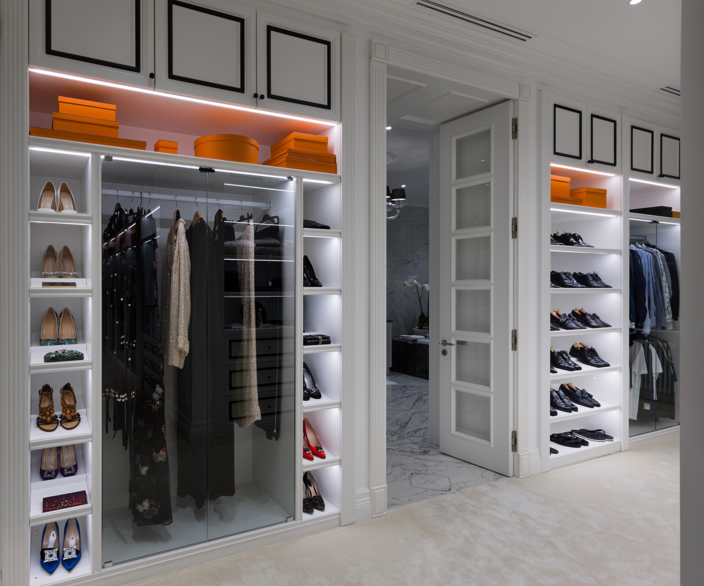 Dressing room featuring a wardrobe with glass doors and shoe shelves with lights