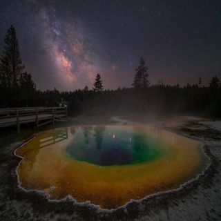 Milky way photographed above the morning glory hot spring in Yellowstone National Park, USA