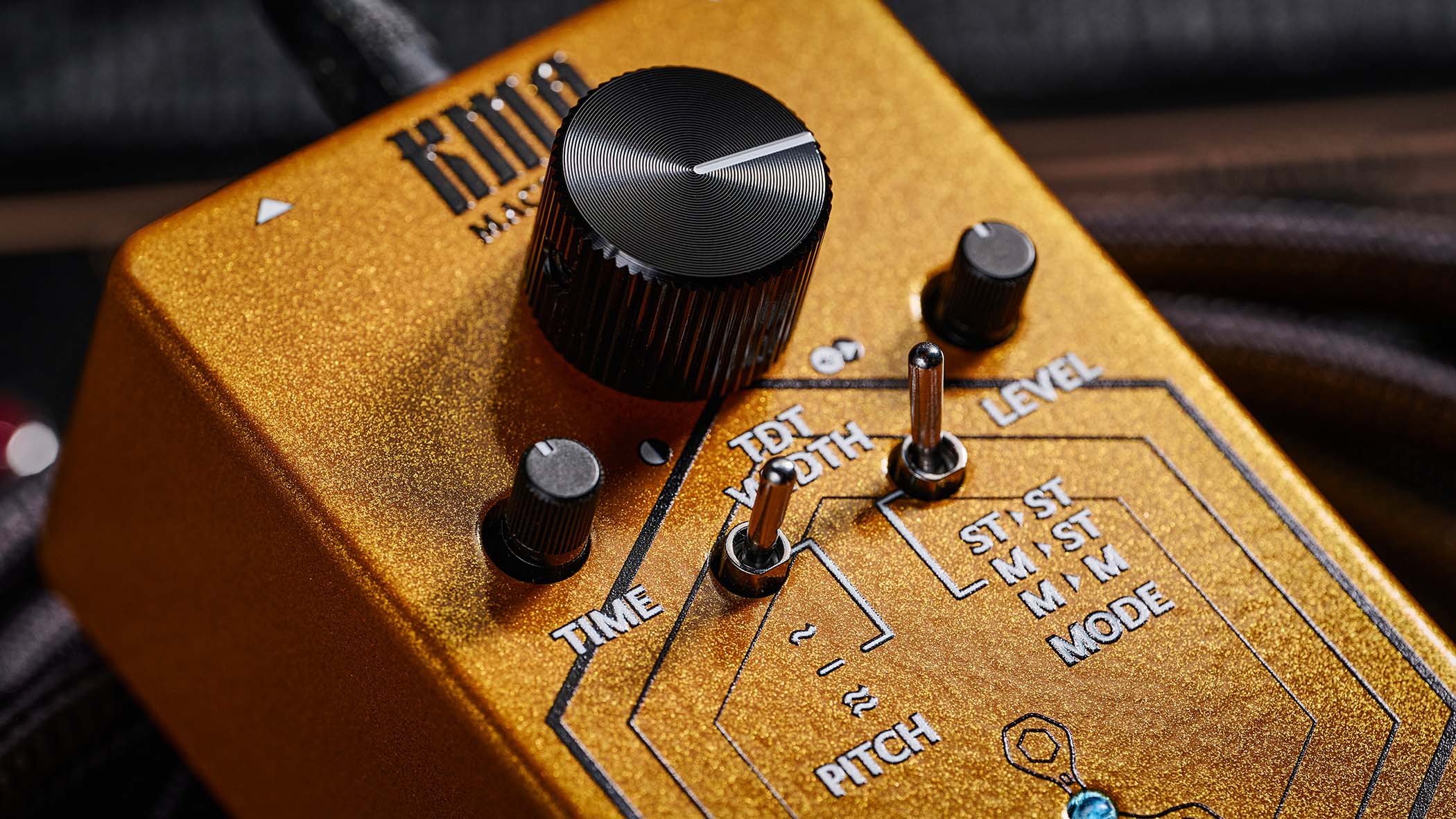 KMA Geminus Stereo True Double Tracker: the gold stompbox&#039;s fascia is dominated by one large black dial and is photographed here in close-up.