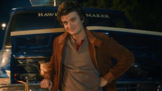 Steve leaning against a van in Stranger Things. 