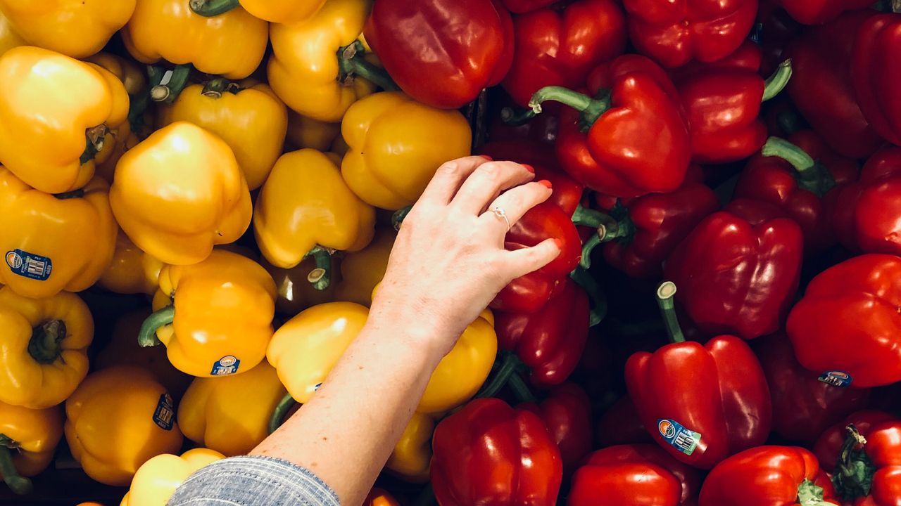 Person reaching for peppers for healthy eating plan