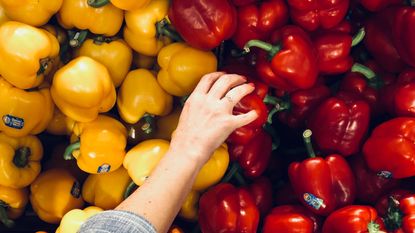 Person reaching for peppers for healthy eating plan