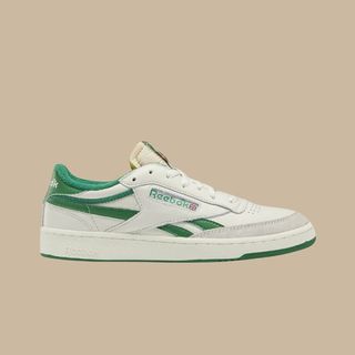 flat lay of reebok green and white trainers on brown background