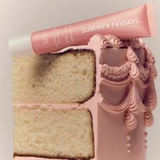 summer fridays lip butter balm laying on pink-frosted slice of vanilla cake