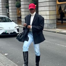 Influencer wears jeans tucked into boots.