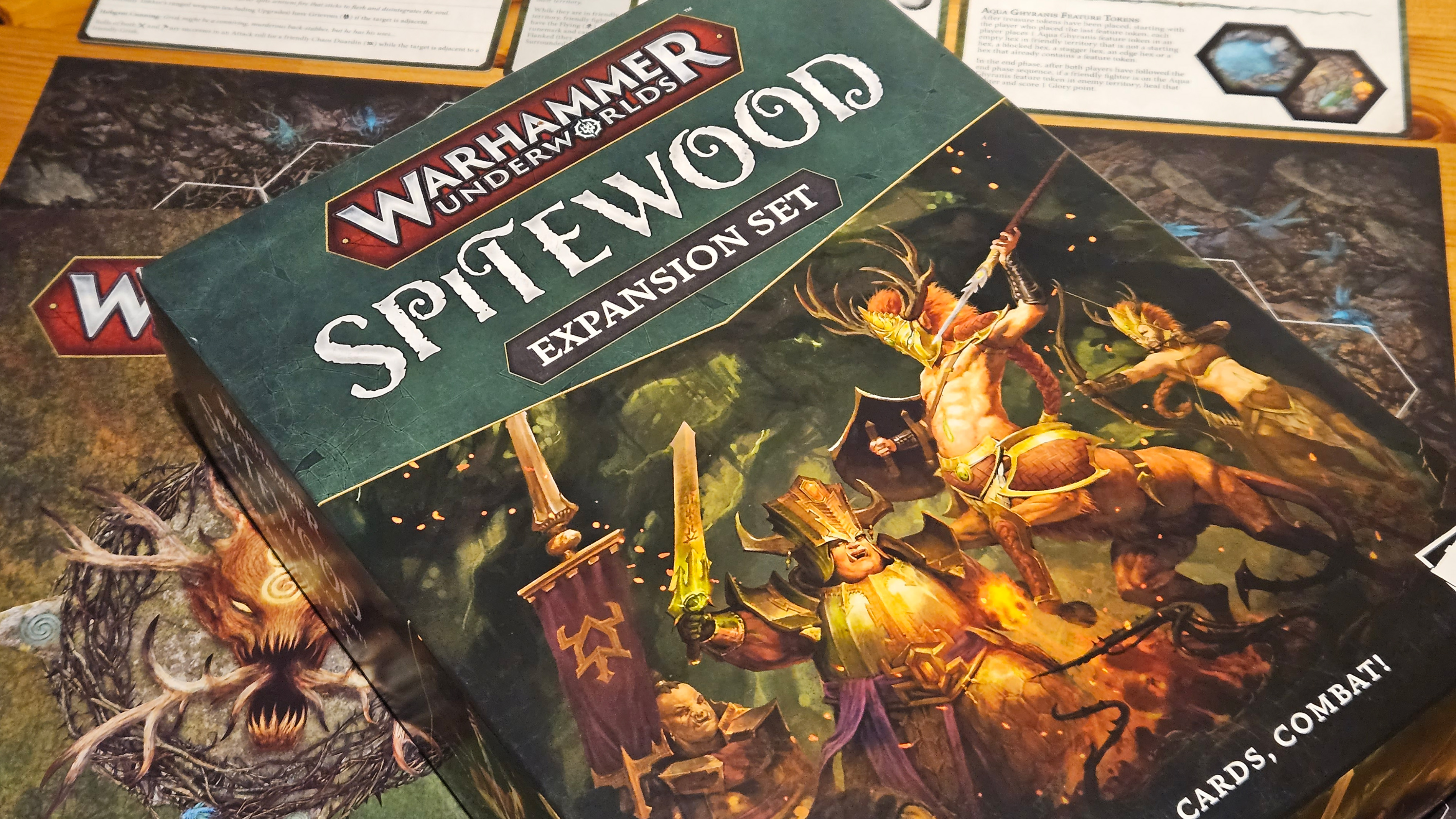 The box art, board, and rule book for Warhammer Underworlds: Spitewood.