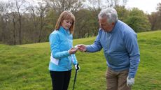 Two golfers look at a golf ball