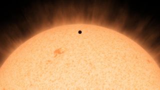 This artist's illustration depicts the silhouette of a rocky planet, HD 219134b transiting its star. Image released July 30, 2015.