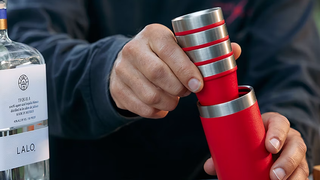 Person putting red Yeti shot glasses into carry case