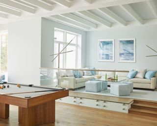 Open plan living space in white and light blues, with designated zones for relaxing and entertaining.