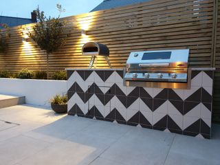 an outdoor kitchen with bold chevron tiles