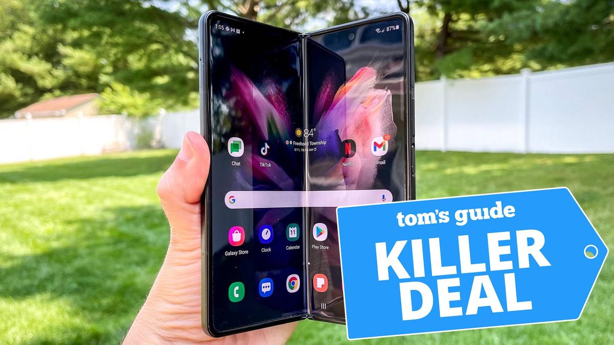 A photo of a person holding a Samsung Galaxy Z Fold 3 phone with the &quot;Tom&#039;s Guide killer deal&quot; tag overlaid