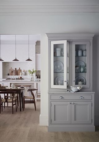 gray larder cabinet dresser with glazed doors with white kitchen behind