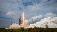 a black and white rocket launches into a cloudy blue sky