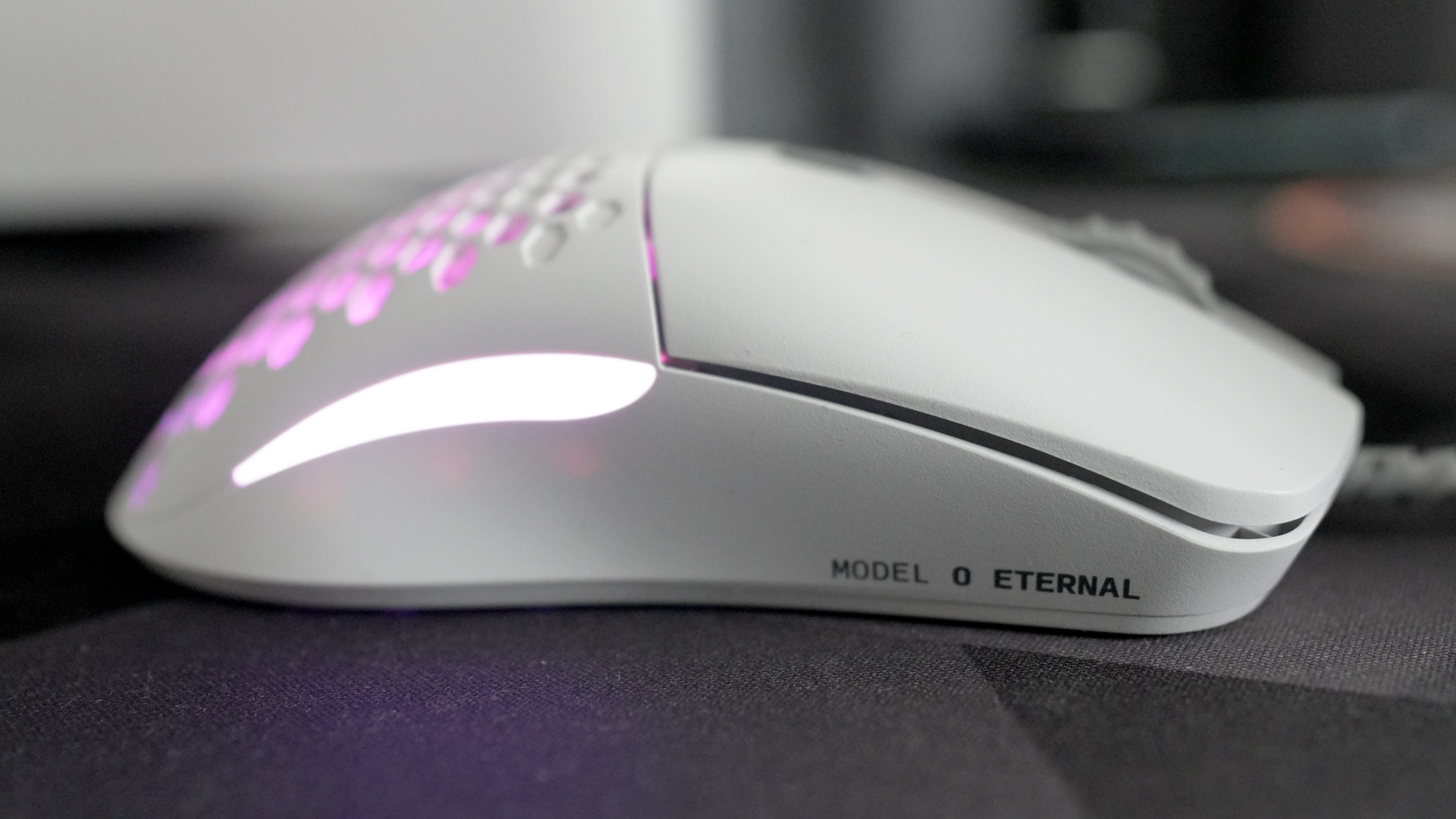 A Glorious Model O Eternal gaming mouse on a mouse mat with the lighting enabled.