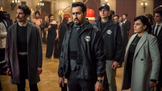 Jonathan Cohen and Noémie Nakai stand at the ready with other Interpol agents in the casino lobby in Army Of Thieves.
