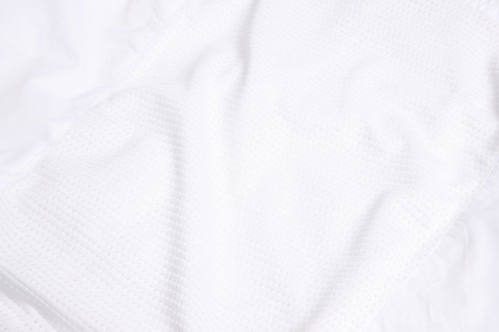 A breathable mesh panel on the rear of a white vest