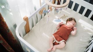 photo of baby in a crib sleeping on her back
