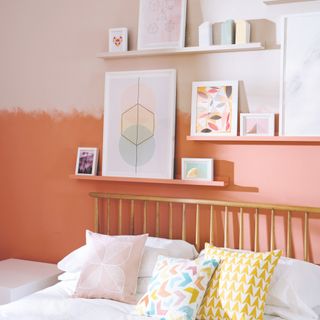 A bedroom with with two-tone walls separated by a painterly effect set against floating shelves