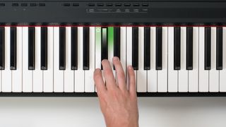 Hand playing black keys on an electronic keyboard