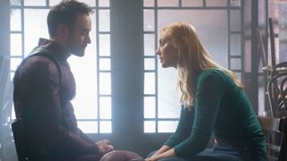 An unmasked Matt Murdock (Charlie Cox) sitting across from Karen Page (Deborah Ann Woll) in Daredevil: Born Again season 2