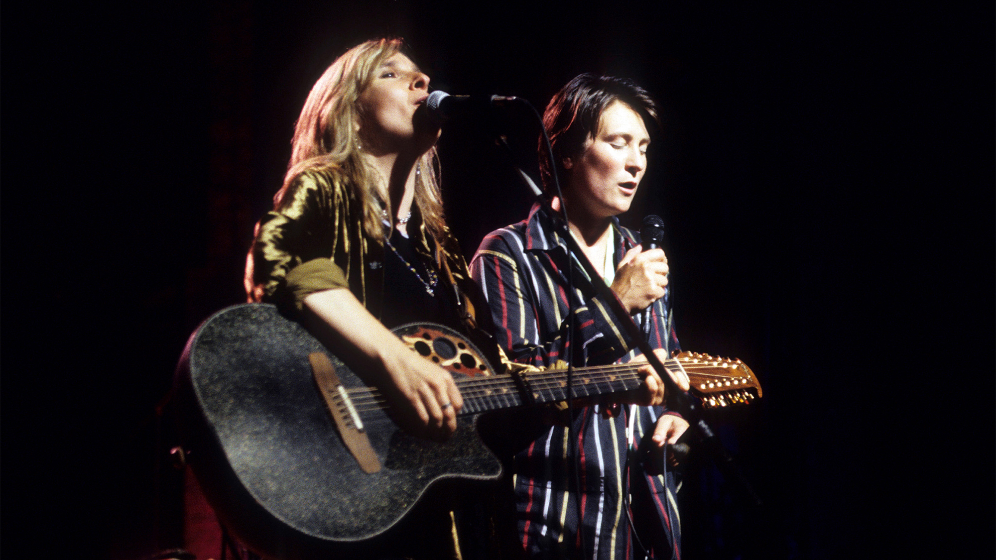 American Folk &amp;amp; Rock musician Melissa Etheridge (left), on acoustic guitar, and Canadian Country &amp;amp; Pop musician kd lang (born Katheryn Dawn Lang) perform, during Lifebeat's 'The Beat Goes On' benefit concert, onstage at the Beacon Theatre, New York, New York, June 24, 1994.