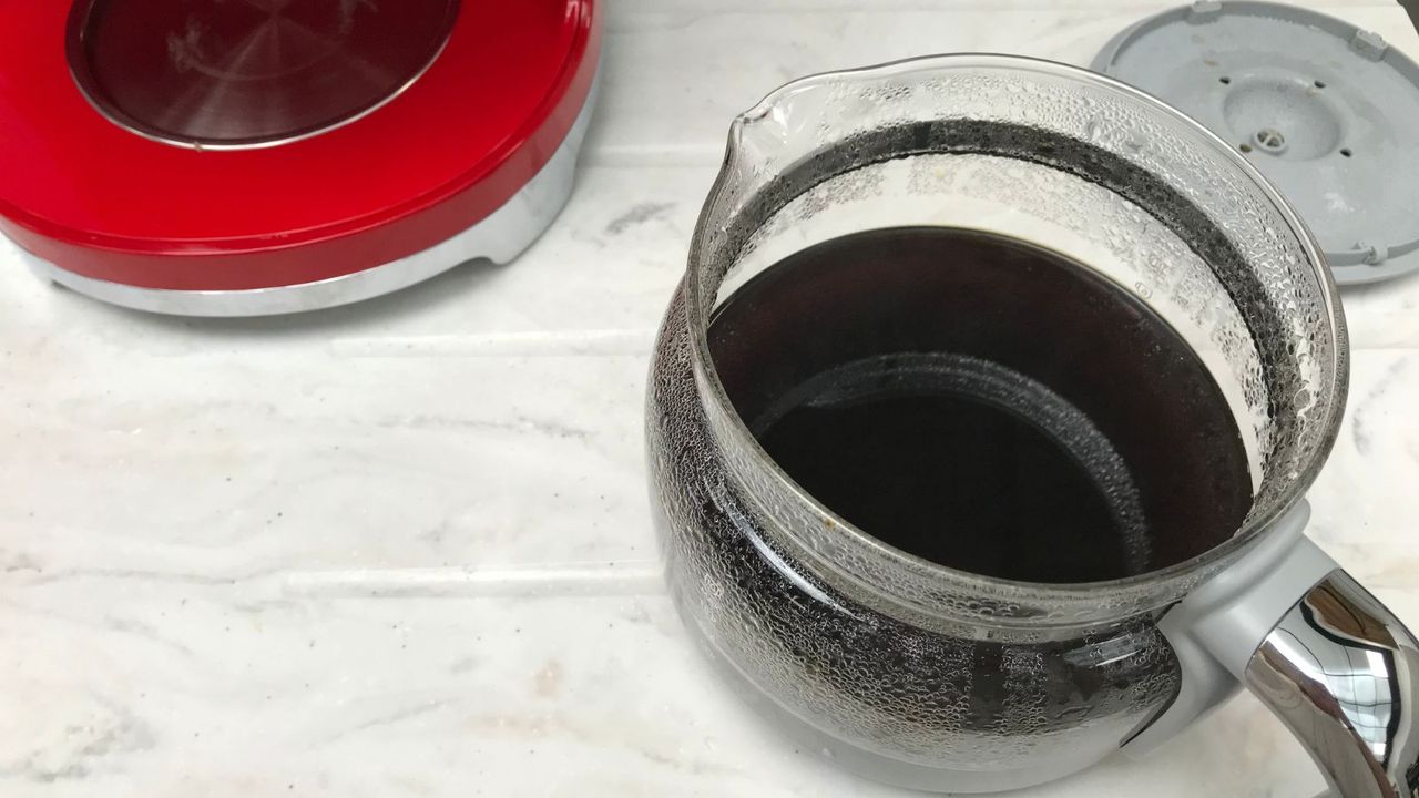 smeg drip coffee maker pot open on the counter showing freshly brewed coffee.