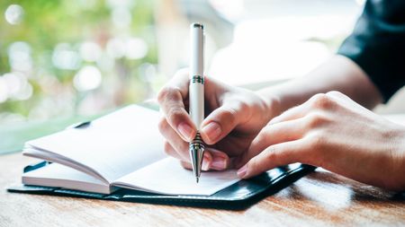 Someone writing in a journal
