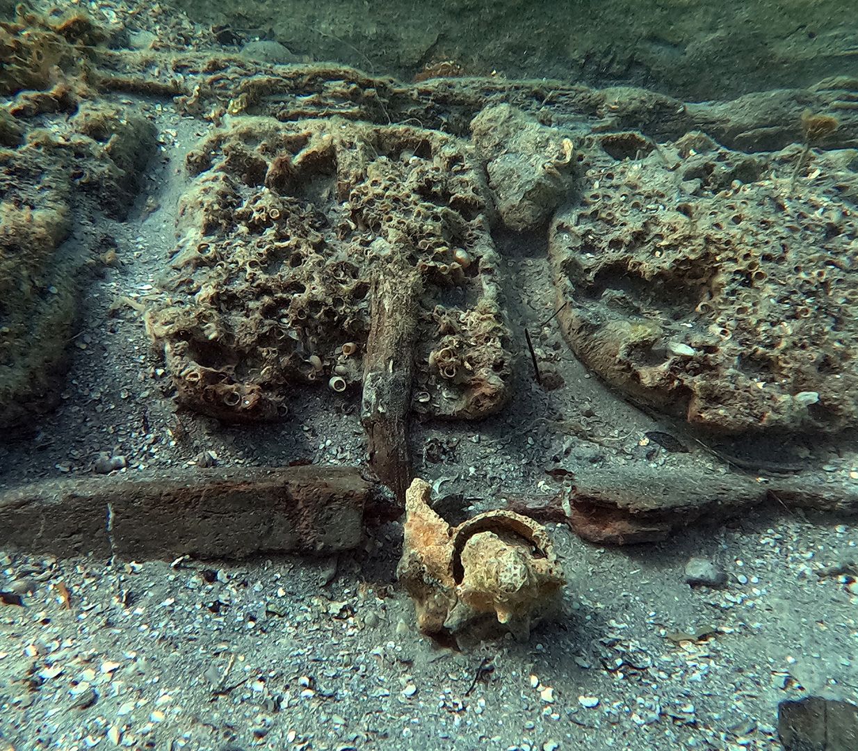 A close up of several shipwreck fragments at the bottom of the seafloor.