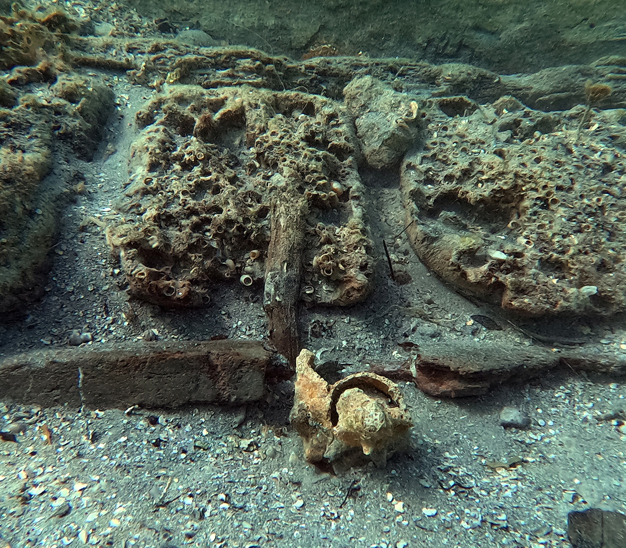 A close up of several shipwreck fragments at the bottom of the seafloor.