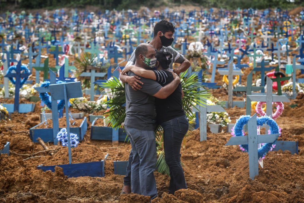 A family in Brazil attends a funeral for someone who died of COVID-19.