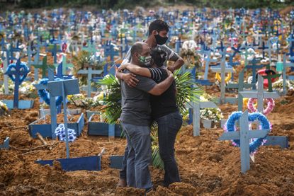 A family in Brazil attends a funeral for someone who died of COVID-19.