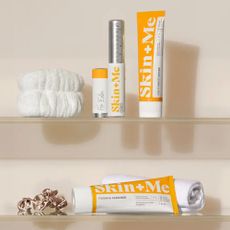 Four Skin + Me products on a glass bathroom shelf with flannels and hair scrunchies