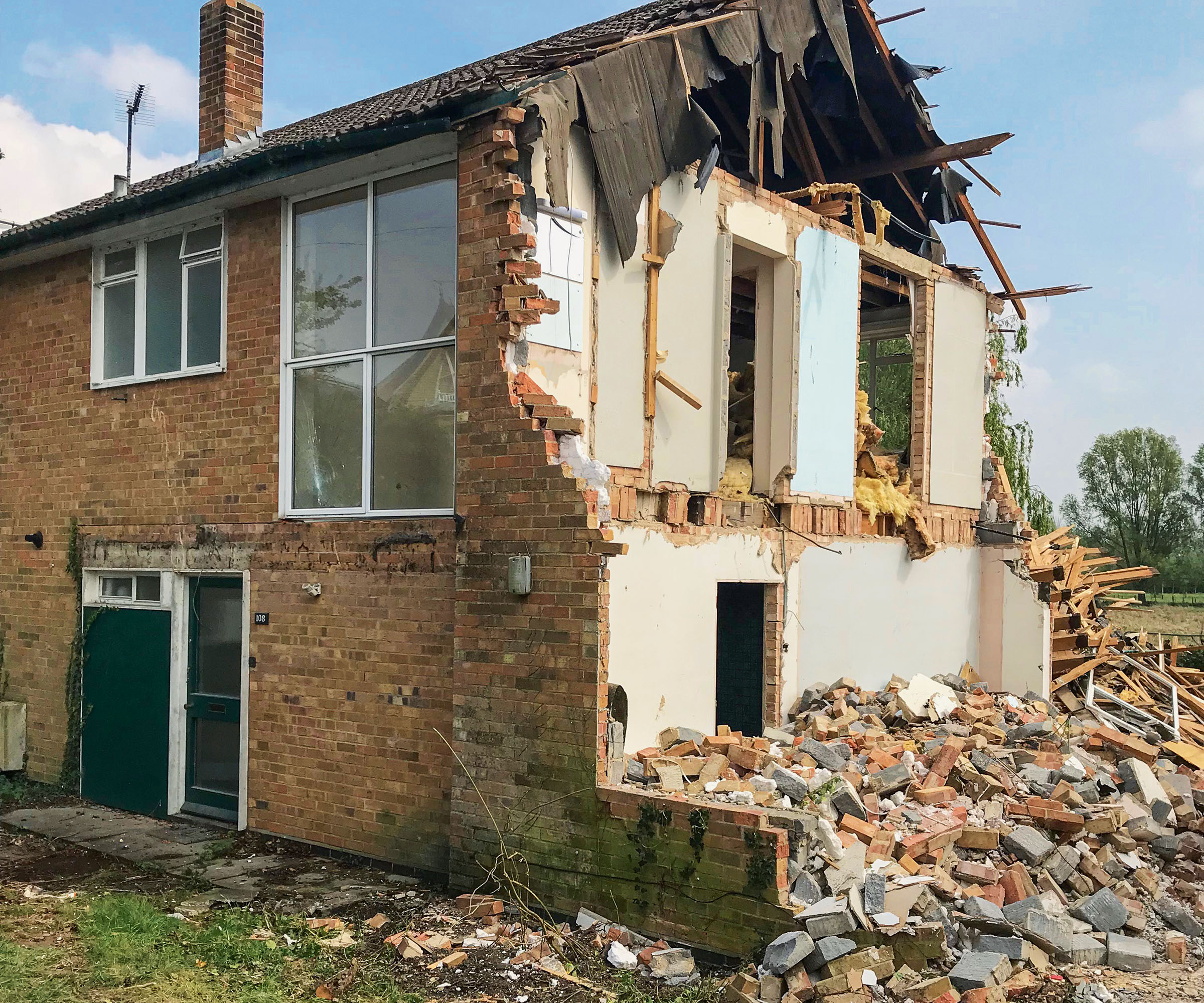 A partially demolished house with bricks and rubble