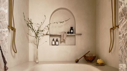 A walk-in shower with a bench that curves around the space, a waterfall showerhead, and two shower heads on opposing walls