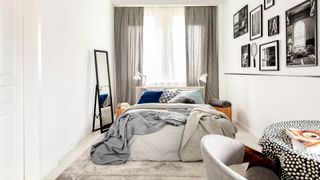 small white bedroom with king sized bed infront of the window to show how impoart layout is for making a small room look bigger
