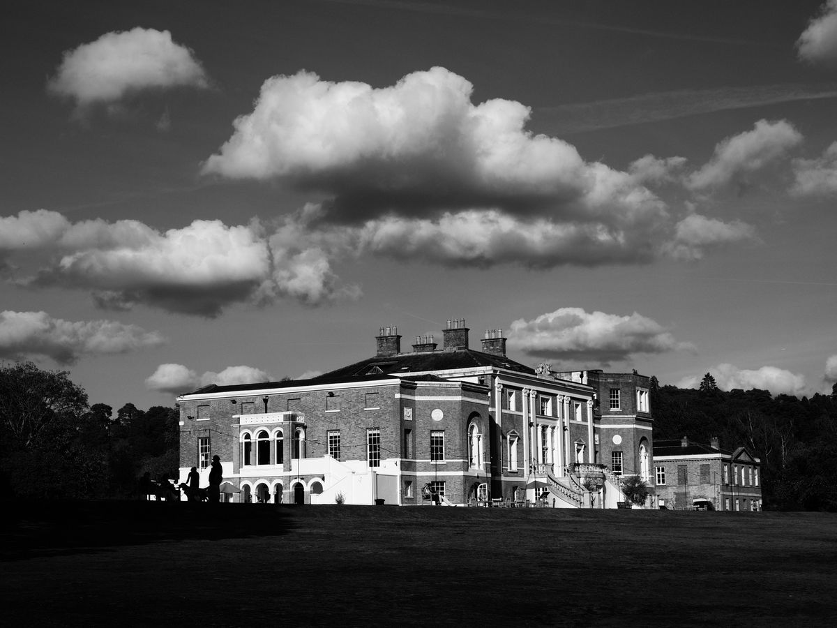 OM System PEN sample gallery: a grand house atop a field, there are dramatic clouds perfectly aligned above it