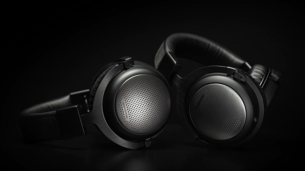 Two pairs of Beyerdynamic T1 (3rd generation) headphones lying side by side a black background.