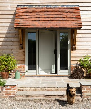 oak frame home with timber cladding and stone front steps