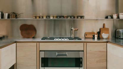 timber kitchen with stainless steel backsplash and timber cutting boards