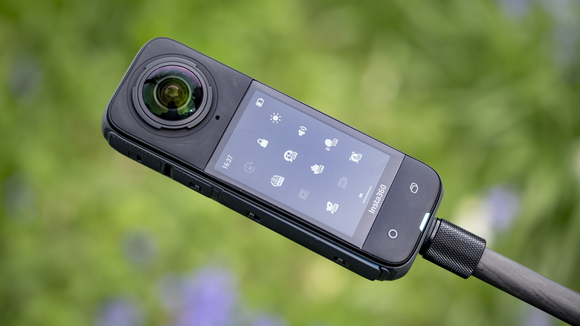 Insta360 X4 360 degree camera outdoors with vibrant grassy background